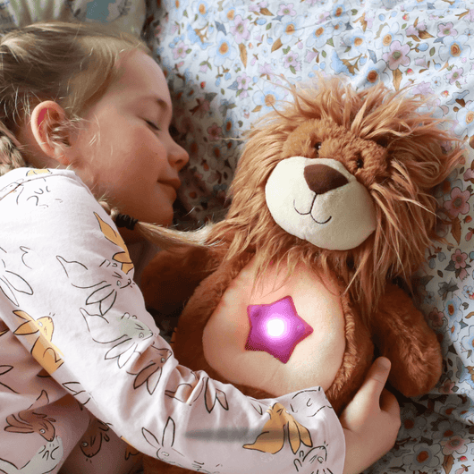 Lion Glow Buddy glowing next to a sleeping girl